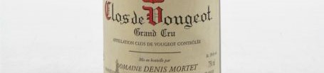 La photo montre une bouteille de vin de Clos Vougeot Grand Cru du Domaine de Denis Mortet situé dans à Gevrey Chambertin en Bourgogne