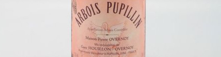 La photo montre une bouteille de vin de l'appellation Arbois du domaine Overnoy dans le Jura.