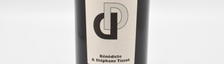 La photo montre une bouteille de vin de l'appellation Arbois du domaine Tissot dans le Jura.